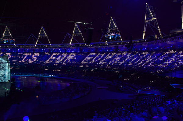 In a stadium at night, the words "This is for everyone" written in lights across the crowd